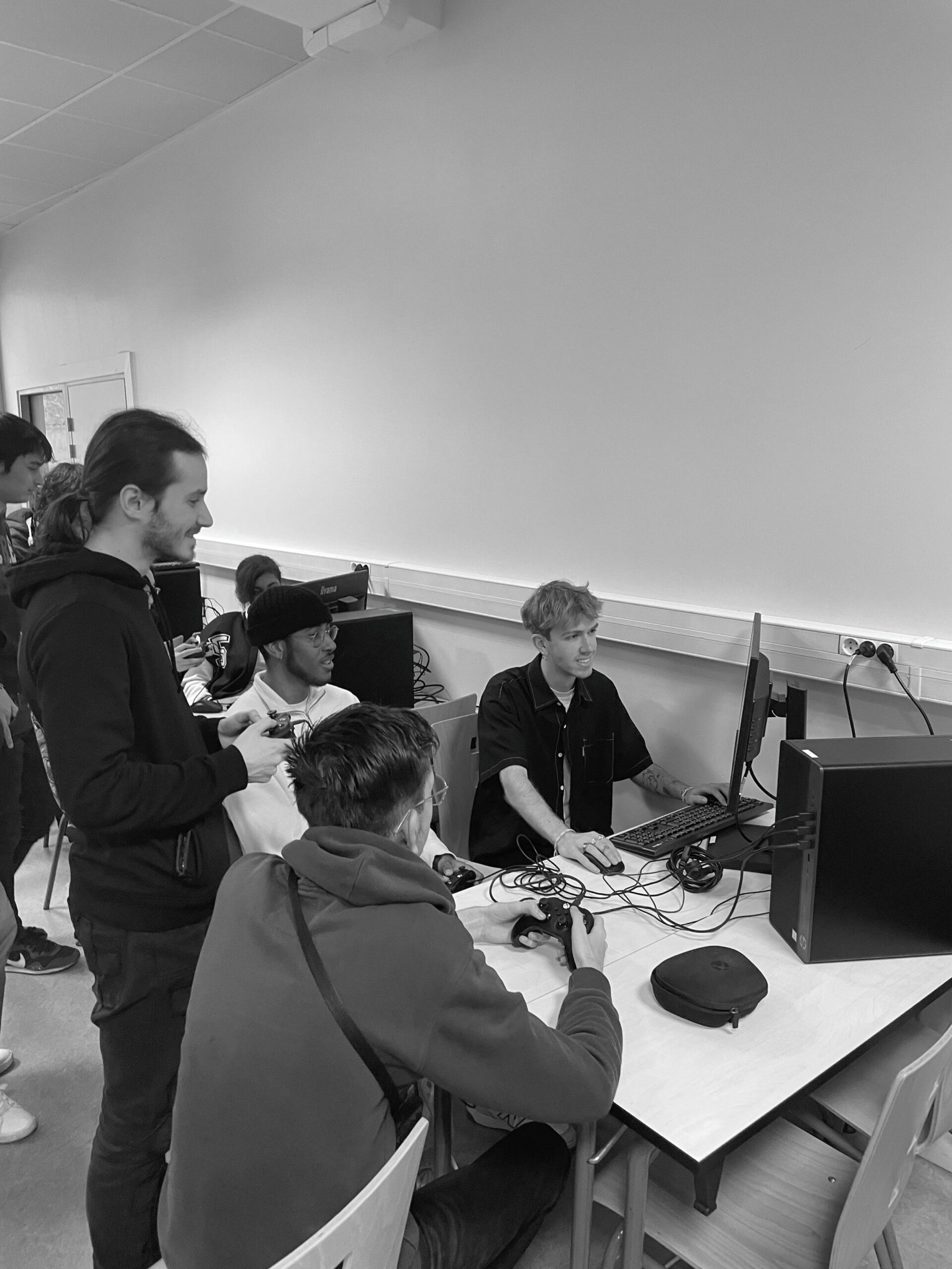 Groupe d'étudiants travaillant autour d’une table lors d’un cours en noir et blanc.