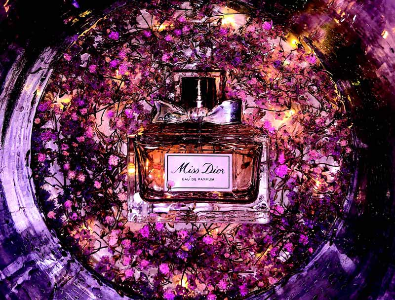 Flacon du parfum Miss Dior au milieu de fleurs