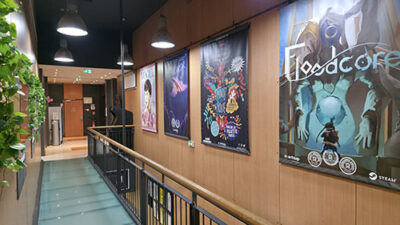 Couloir du campus e-artsup Bordeaux décoré avec affiches de jeux vidéo et projets créatifs étudiants