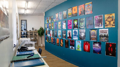 Couloir d’exposition présentant des affiches et créations graphiques d’étudiants