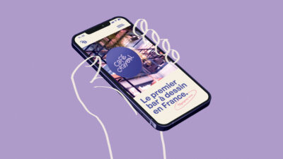 Smartphone affichant l’interface d’un site de café créatif avec éléments dessinés à la main sur fond violet pastel minimaliste.