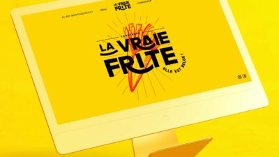 Écran d’ordinateur présentant le site web d’un food truck belge au design graphique jaune vif et typographie expressive.