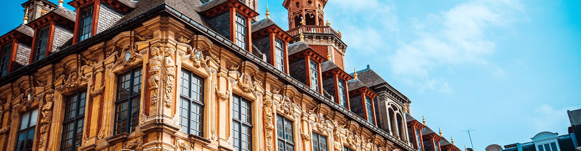 Architecture flamande et baroque de la Vieille Bourse de Lille sous un ciel bleu lumineux