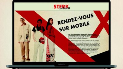 Ordinateur portable présentant une landing page mode pour une collaboration Carhartt au design éditorial rouge, noir et beige.