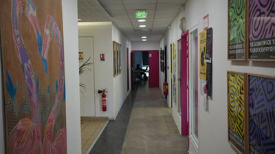 Couloir du campus décoré de fresques et affiches artistiques