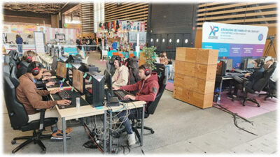 Compétition e-sport avec étudiants jouant sur ordinateurs équipés de casques gaming