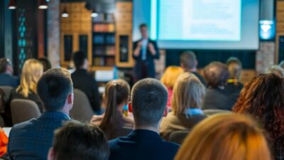 Public assistant à une conférence professionnelle sur l’esport et les métiers du gaming dans une salle de séminaire moderne.