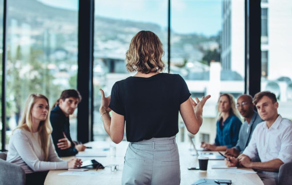 Formatrice animant une réunion professionnelle autour des métiers de l’événementiel et de la communication digitale.