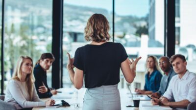 Formatrice animant une réunion professionnelle autour des métiers de l’événementiel et de la communication digitale.
