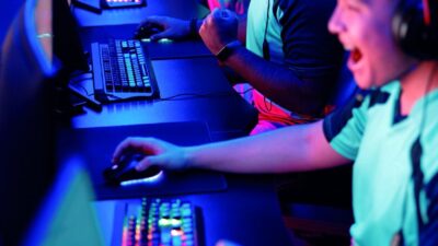 Joueurs esport célébrant une victoire pendant une compétition gaming multijoueur sur PC.