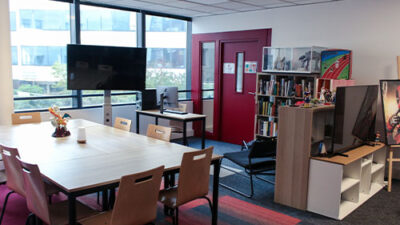 Salle de travail collaborative avec bibliothèque et écran de présentation