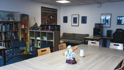 Salle de réunion et espace créatif avec bibliothèque et objets de collection