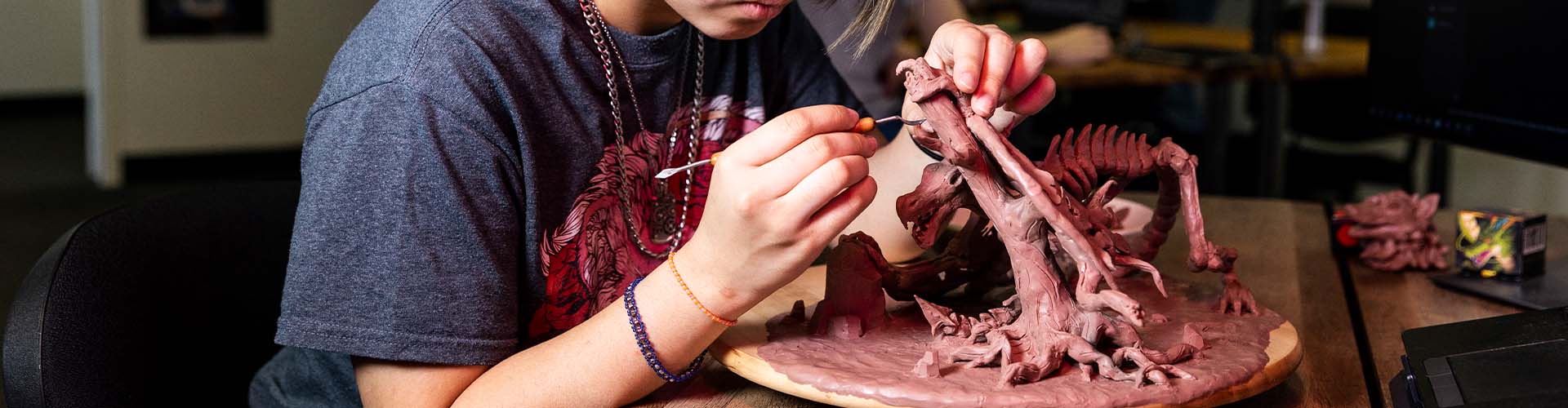 Étudiant sculptant une créature fantastique en Monster Clay lors d’un atelier de character design