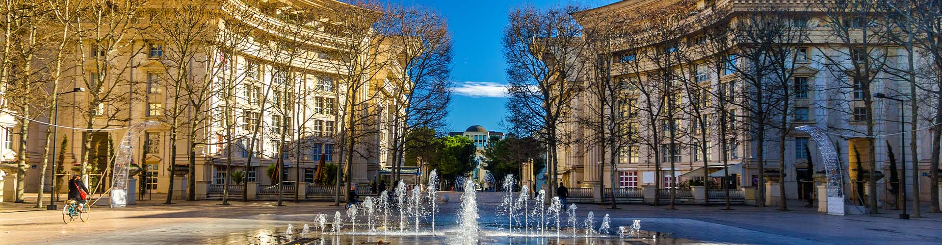 Vue urbaine de Montpellier avec bâtiments contemporains et esplanade piétonne ensoleillée