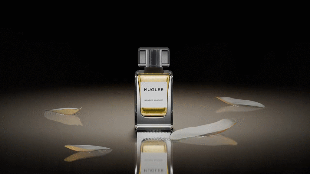 Flacon de parfum Mugler au centre d’une composition 3D élégante sur fond sombre, pétales au sol