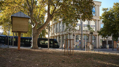 Vue du campus e-artsup Montpellier entouré d’arbres et du tramway urbain