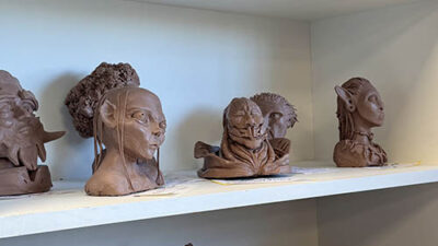 Sculptures et bustes de personnages réalisés par les étudiants exposés sur des étagères