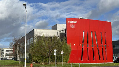 Façade rouge du campus e-artsup Tours vue depuis l’extérieur sous un ciel nuageux