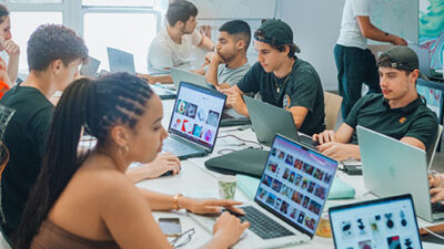 Atelier de création numérique avec étudiants travaillant sur des projets graphiques
