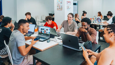 Salle de classe collaborative avec étudiants travaillant sur des projets créatifs
