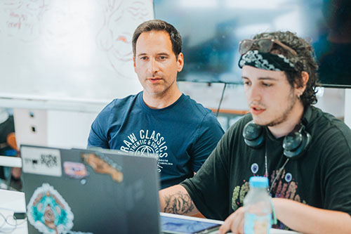 Intervenant et étudiant travaillant ensemble sur un projet digital en cours de création