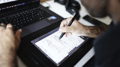 Étudiant dessinant un personnage sur tablette graphique pendant un cours de character design