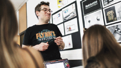 Intervenant présentant un projet créatif à des étudiants pendant un cours de design graphique