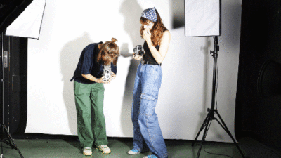Étudiantes utilisant des appareils photo en studio photo équipé de lumières professionnelles
