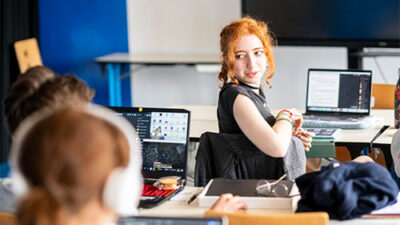 Étudiante en cours de création digitale dans une salle informatique du campus