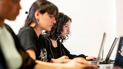 Étudiantes travaillant sur ordinateur pendant un cours de création numérique
