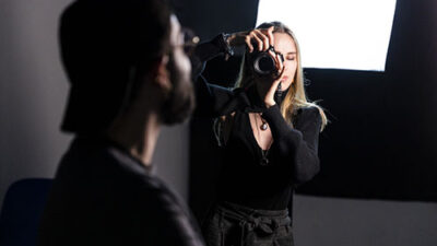 Étudiante prenant une photographie en studio photo avec éclairage professionnel