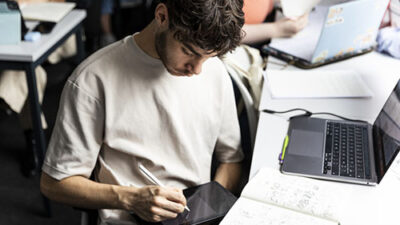 Étudiant dessinant sur tablette graphique pendant un cours de création digitale à e-artsup Toulouse