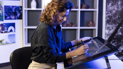 Étudiante travaillant sur une tablette graphique professionnelle dans un studio de création numérique