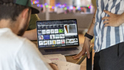 Étudiants travaillant sur un projet numérique et design 3D autour d’un ordinateur portable