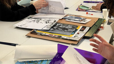 Présentation de carnets de croquis et travaux artistiques sur une table d’atelier