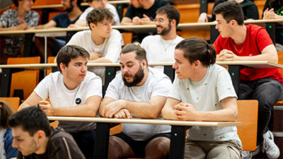 Étudiants échangeant dans un amphithéâtre pendant une conférence ou un cours
