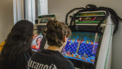 Étudiants jouant sur une borne d’arcade dans un espace détente du campus