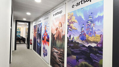 Couloir du campus e-artsup Strasbourg décoré avec des affiches et illustrations de projets étudiants