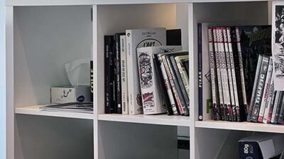 Bibliothèque et espace créatif e-artsup avec livres d’art, bombes de peinture et objets d’inspiration visuelle