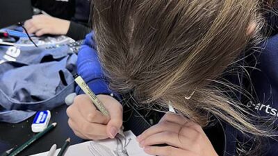 Étudiante réalisant un dessin traditionnel de créature fantastique lors d’un atelier artistique e-artsup