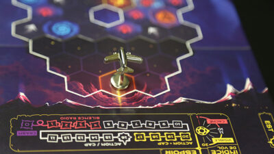 Gros plan sur le plateau du jeu “Vol de Nuit” avec pion avion et interface graphique de jeu de société narratif.