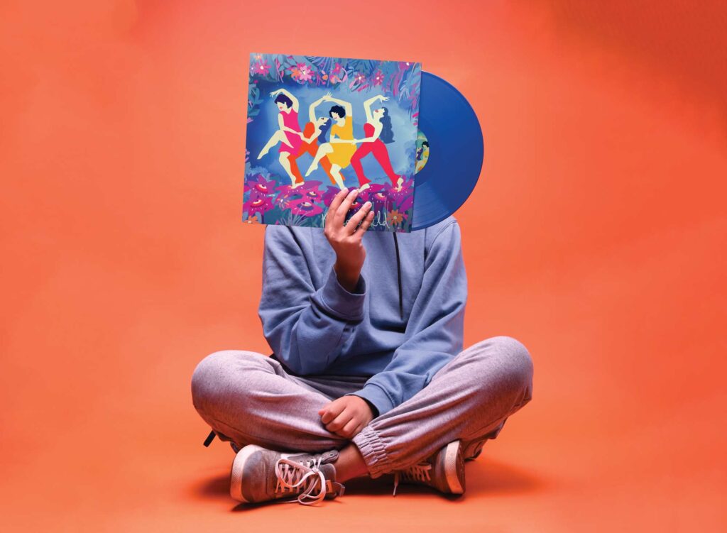 Personne assise en tailleur tenant une pochette de vinyle avec une illustration colorée sur fond orange