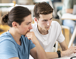 Deux étudiants de l'école de design e-artsup concentrés devant un ordinateur portable lors d'un cours.