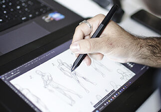 Personne qui dessine des personnage sur une tablette graphique