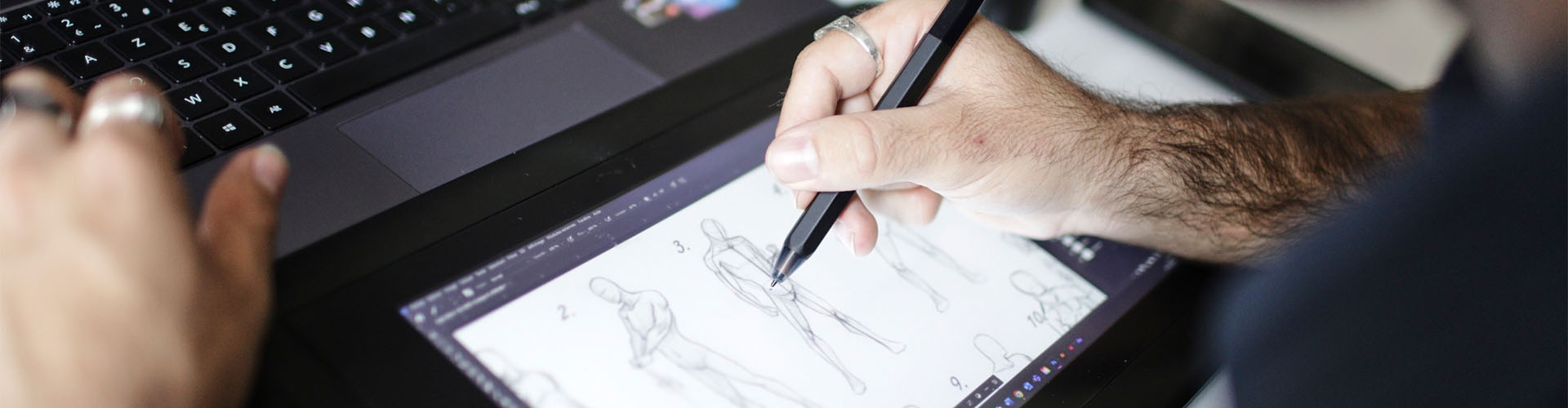 Etudiant réalisant des croquis d'un personnage sur une tablette graphique
