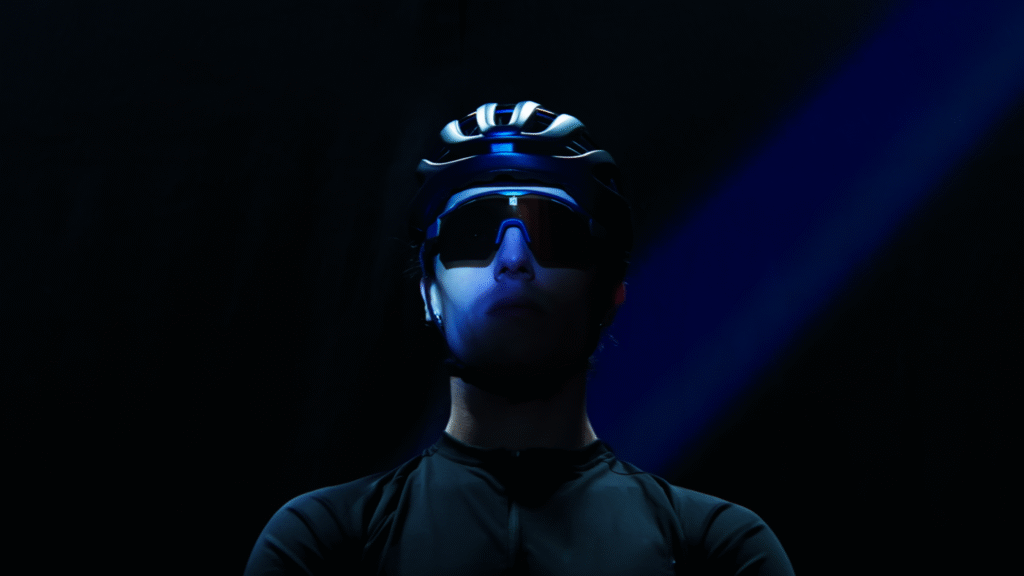 Portrait sombre d’une personne éclairée par une lumière bleue avec des lunettes de vélo