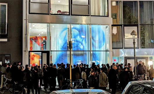 Rassemblement de personnes devant une galerie d'art