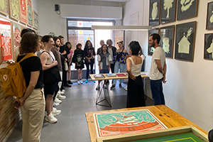 Groupe d'étudiants internationaux visitant une galerie d'art et un atelier de sérigraphie.