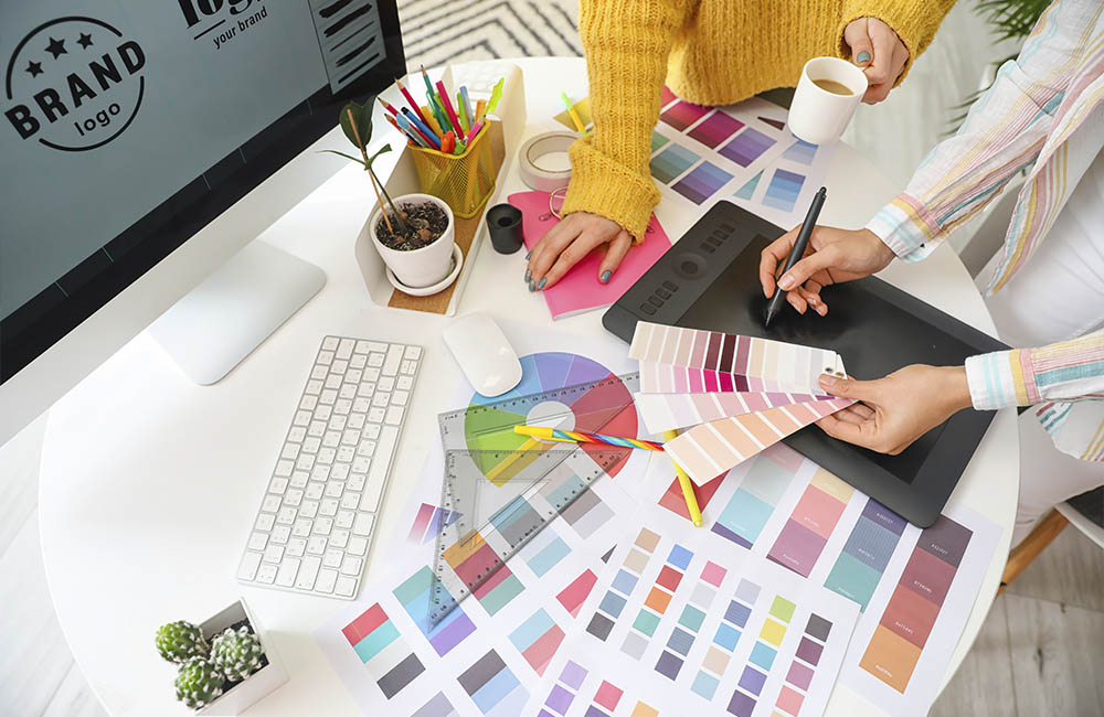 2 personnes autour d'une table sur laquelle sont posés des palettes de couleurs