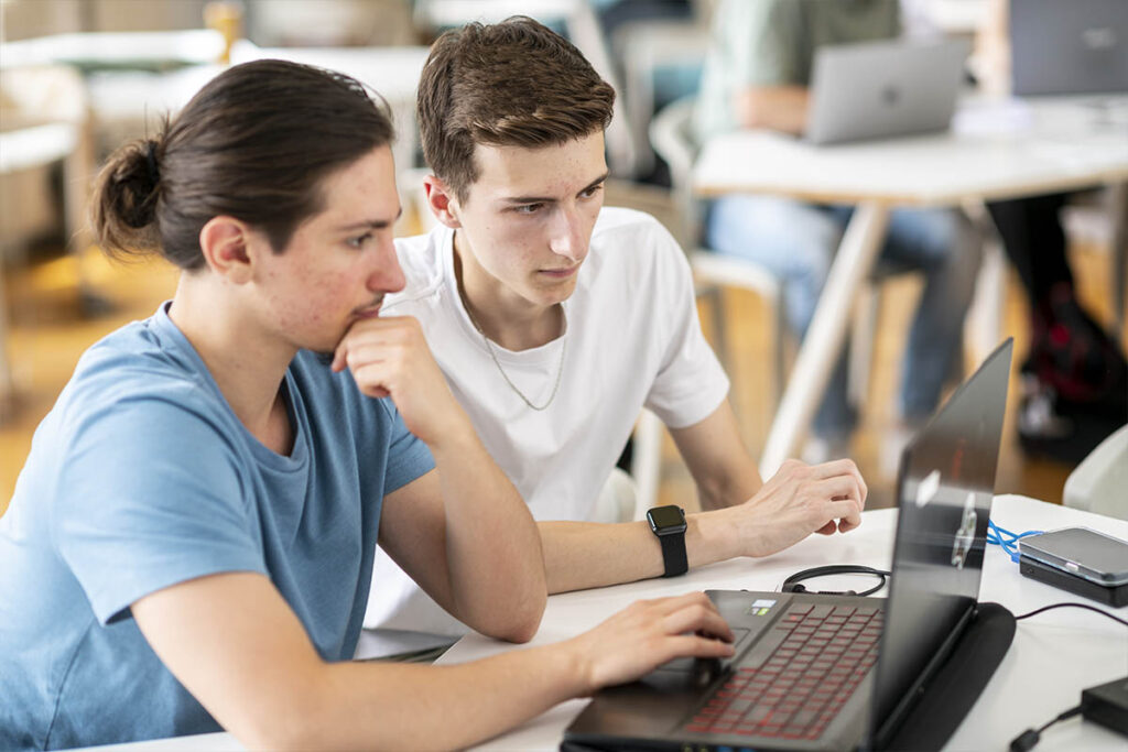 2 étudiants travaillant sur un projet de classe sur ordinateur